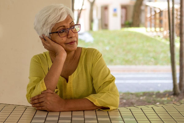 Menopause and anxiety: An older woman rests her head on her hand and stares into the distance