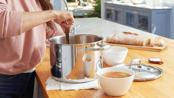 Bone broth diet: A woman scoops broth from a stock pot